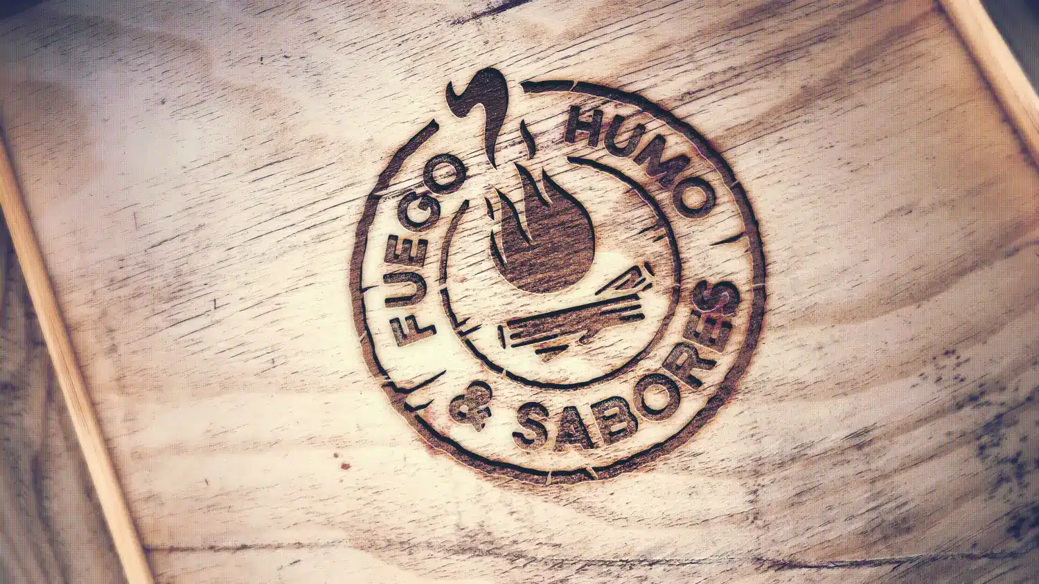 Fuego Humo y Sabores logo engraved in wood